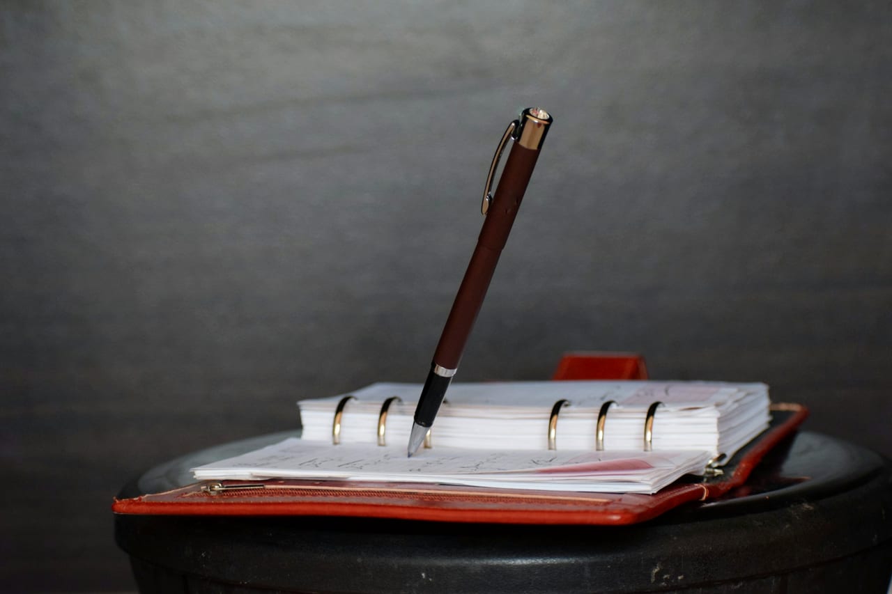 A click pen resting on a plain white notebook