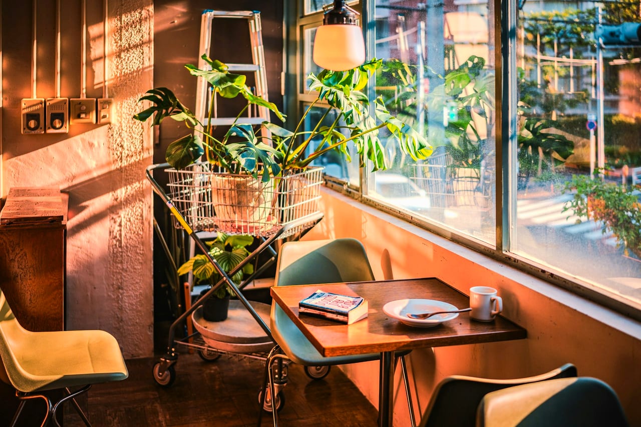 A quiet café corner with a table, chairs and a window
