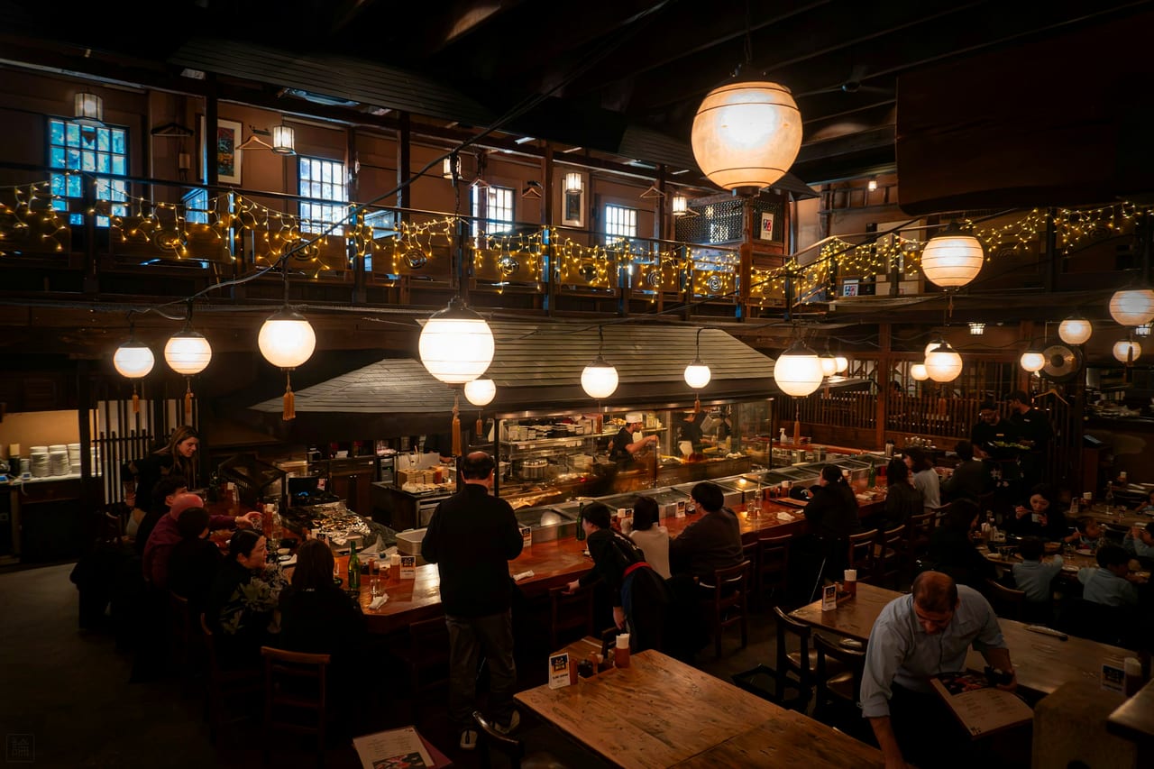 A busy restaurant interior at night under warm light.