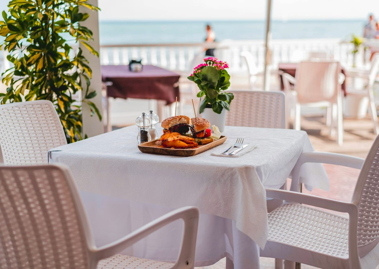 A white plate on a bright, sunlit table.
