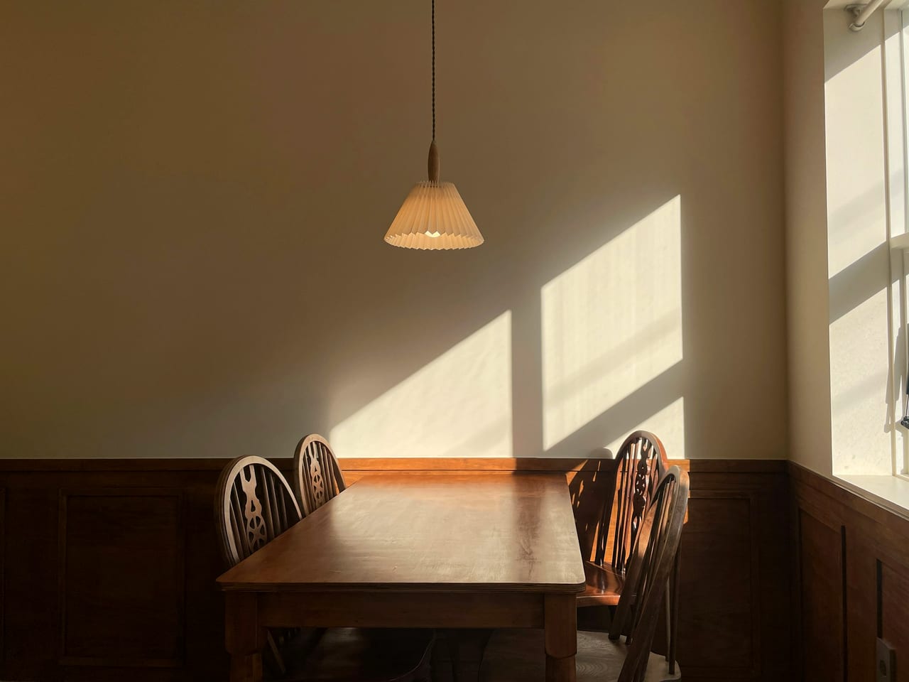 A wooden café table bathed in sunlight