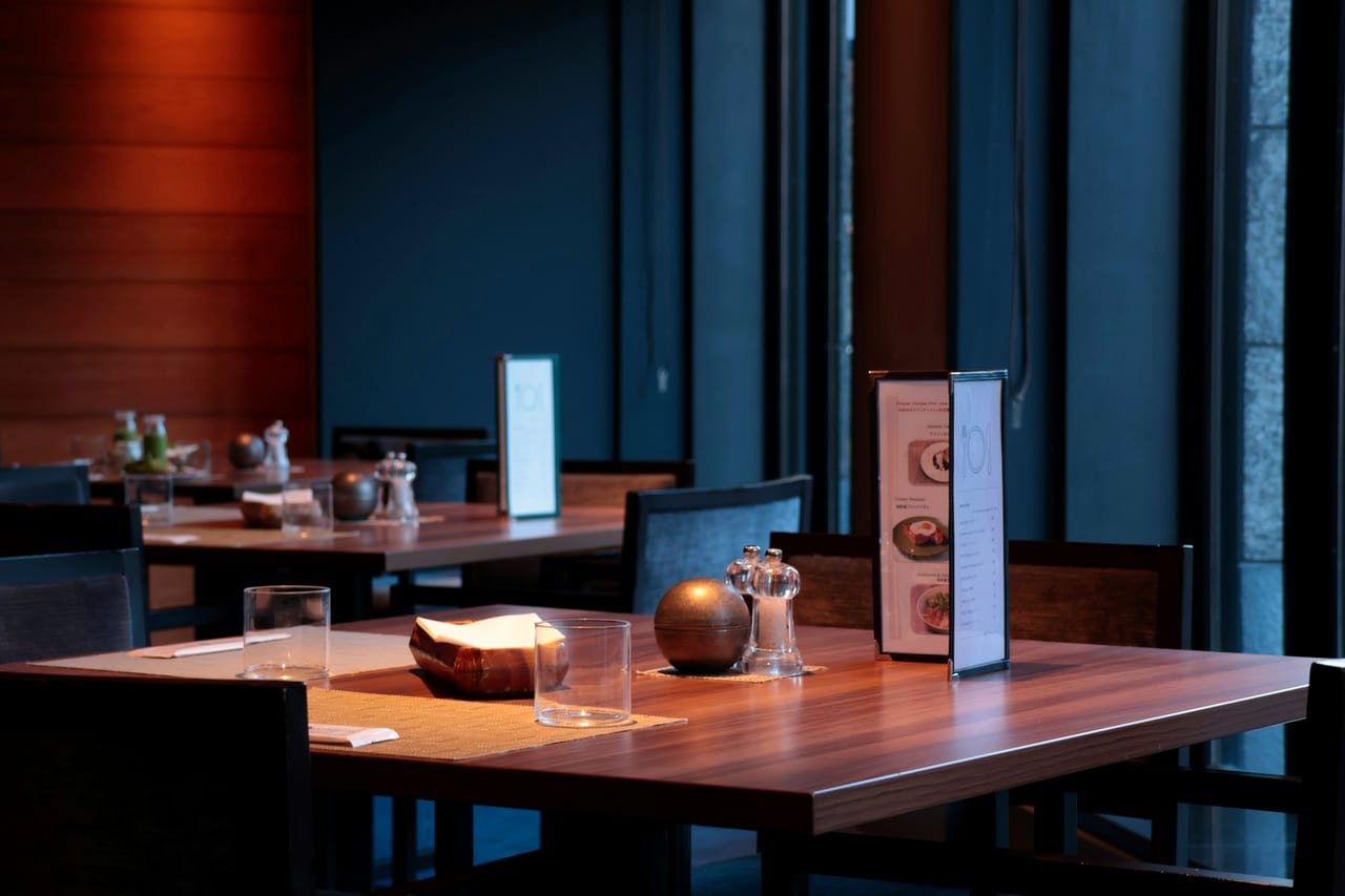 A modern restaurant interior with empty wooden tables