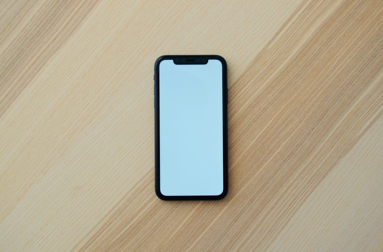 A smartphone with a blank screen on a wooden table