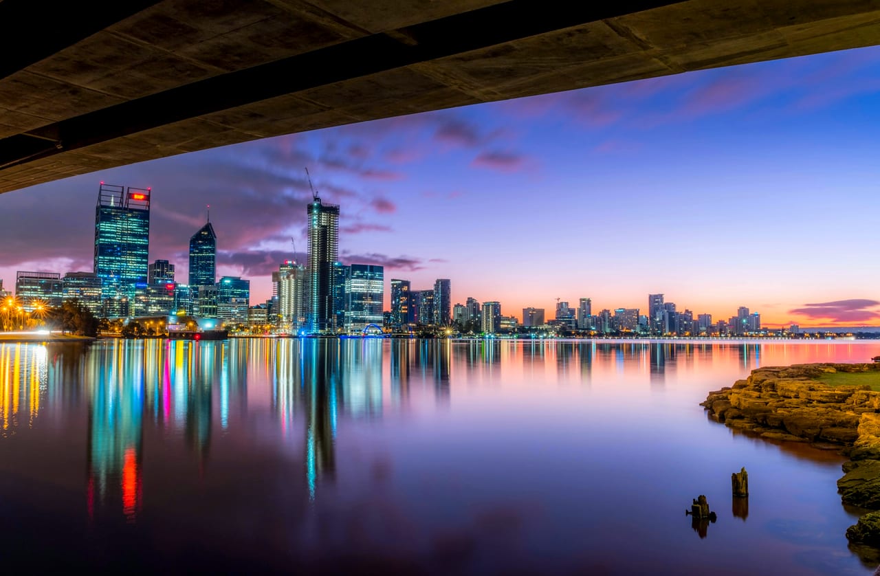 The Perth skyline reflected in the Swan River at dusk.