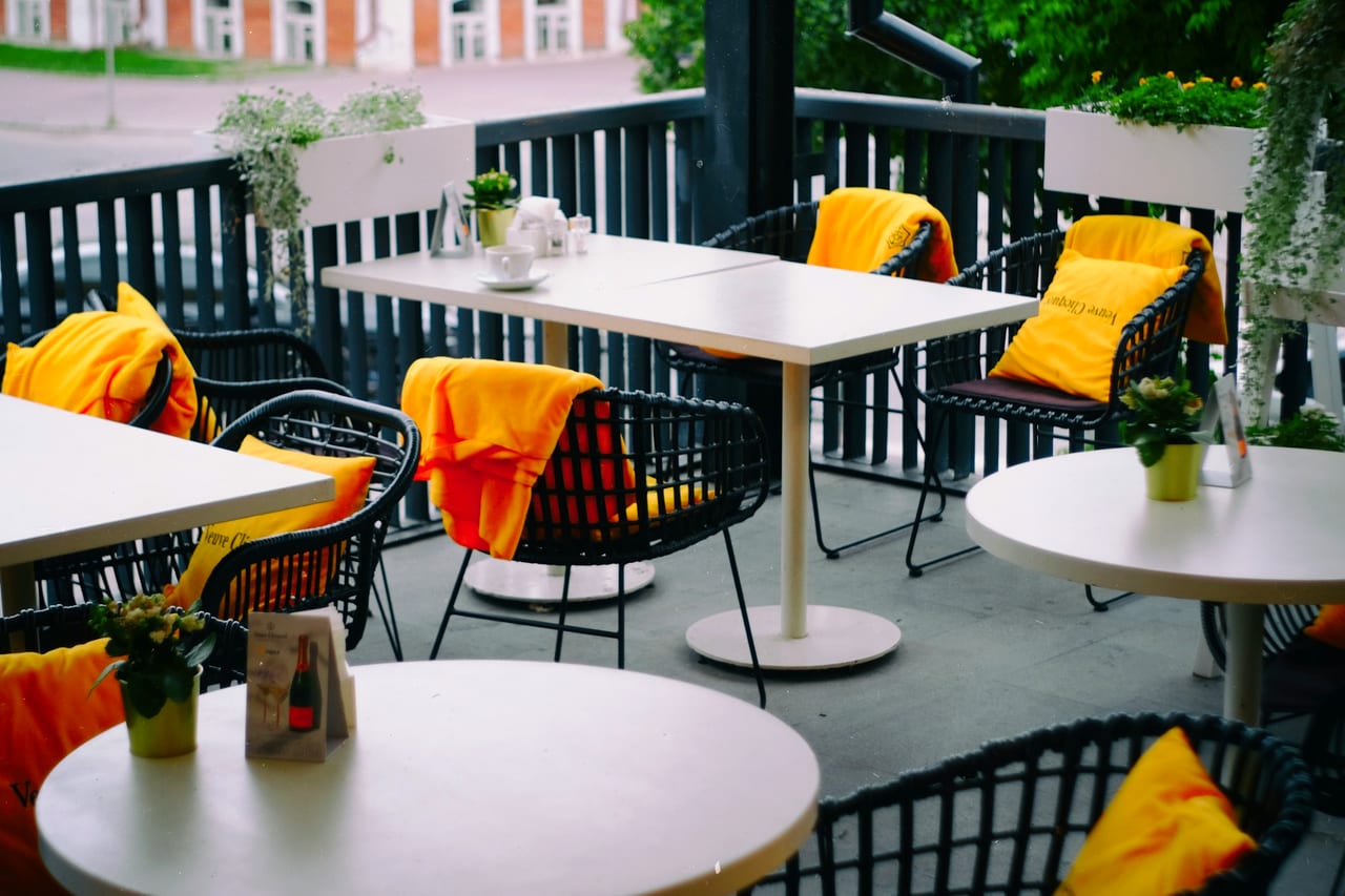 A bright outdoor café table and chair.