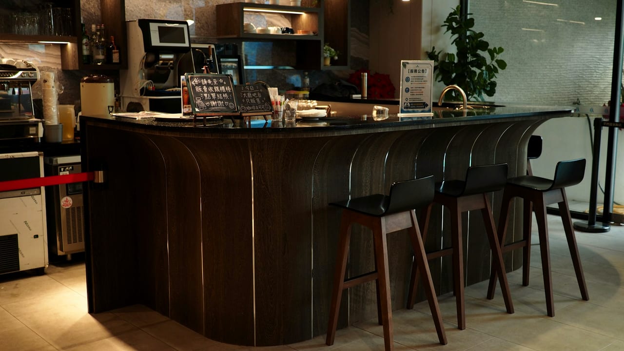 A curved front-of-house counter with stools.