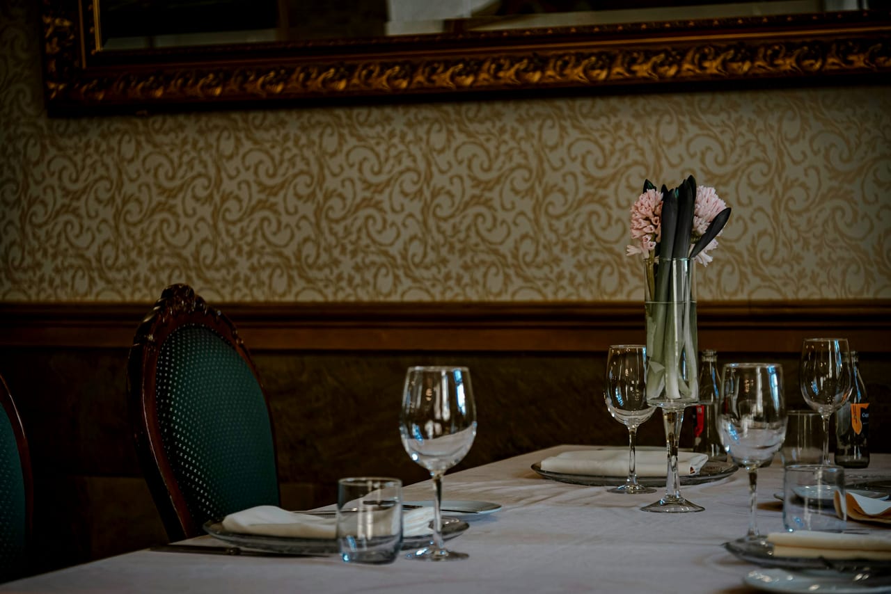 A restaurant table set for a meal with wine glasses