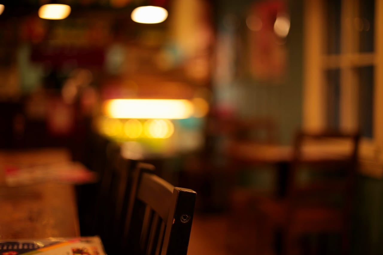 A warm restaurant dining room with a table and chairs