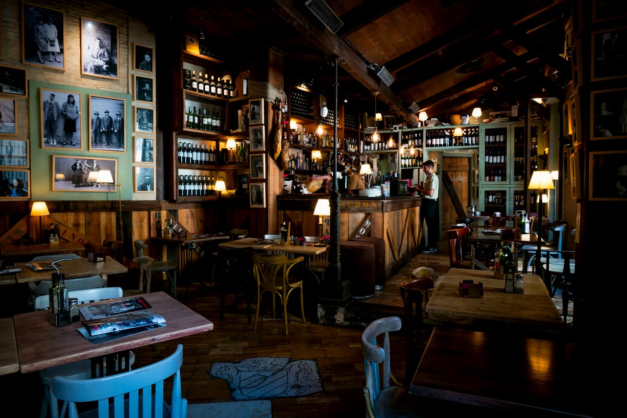 A Northern Quarter bar mid-evening, bottles backlit along the counter