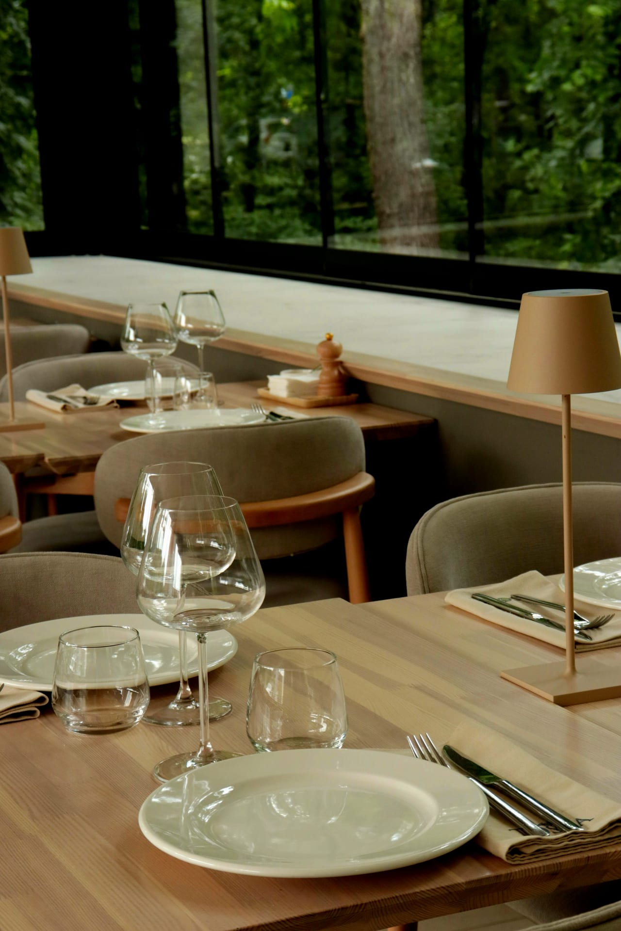 Restaurant tables laid with plates and glasses, waiting for guests