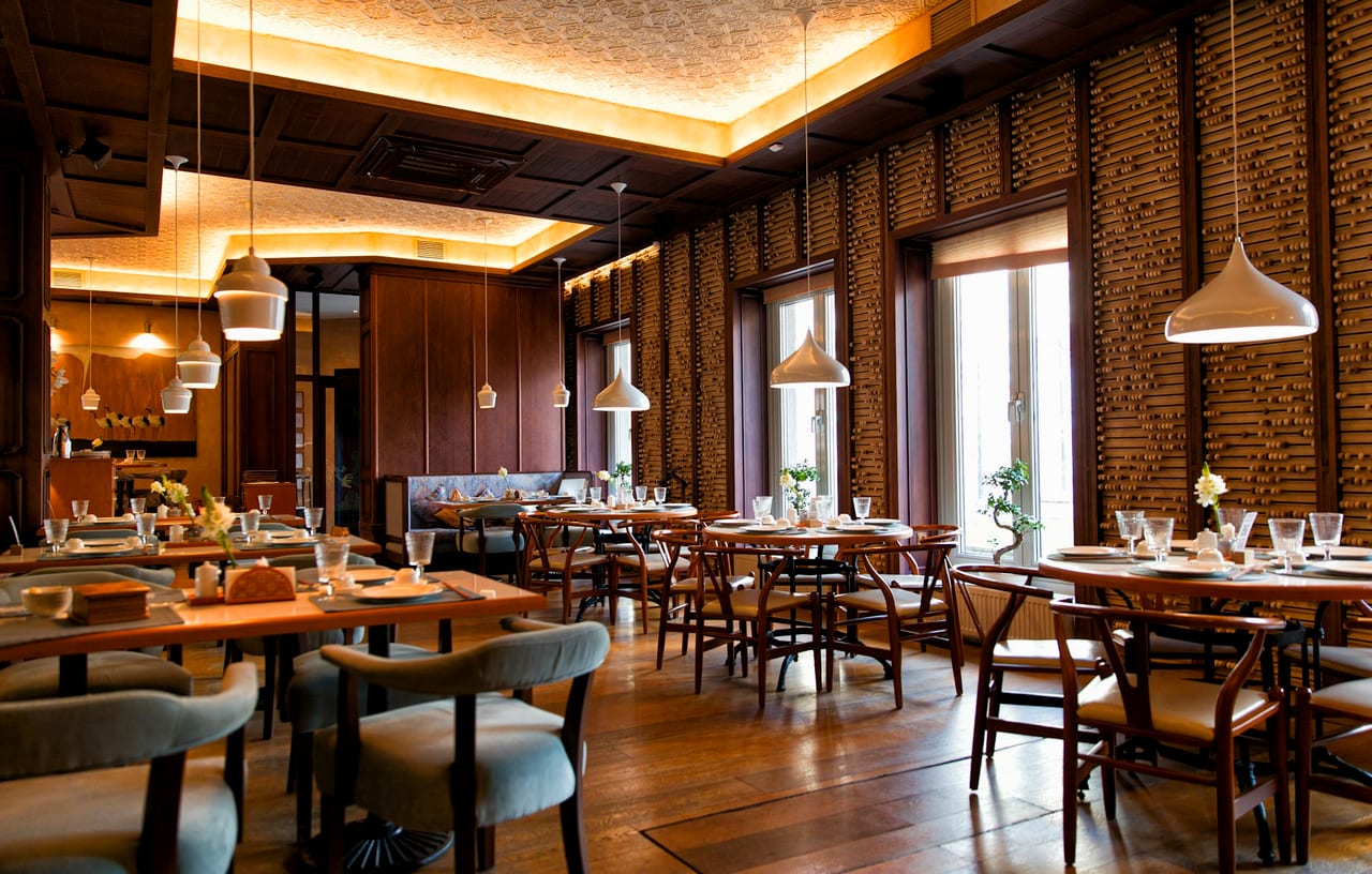 A warm restaurant dining room under pendant lights