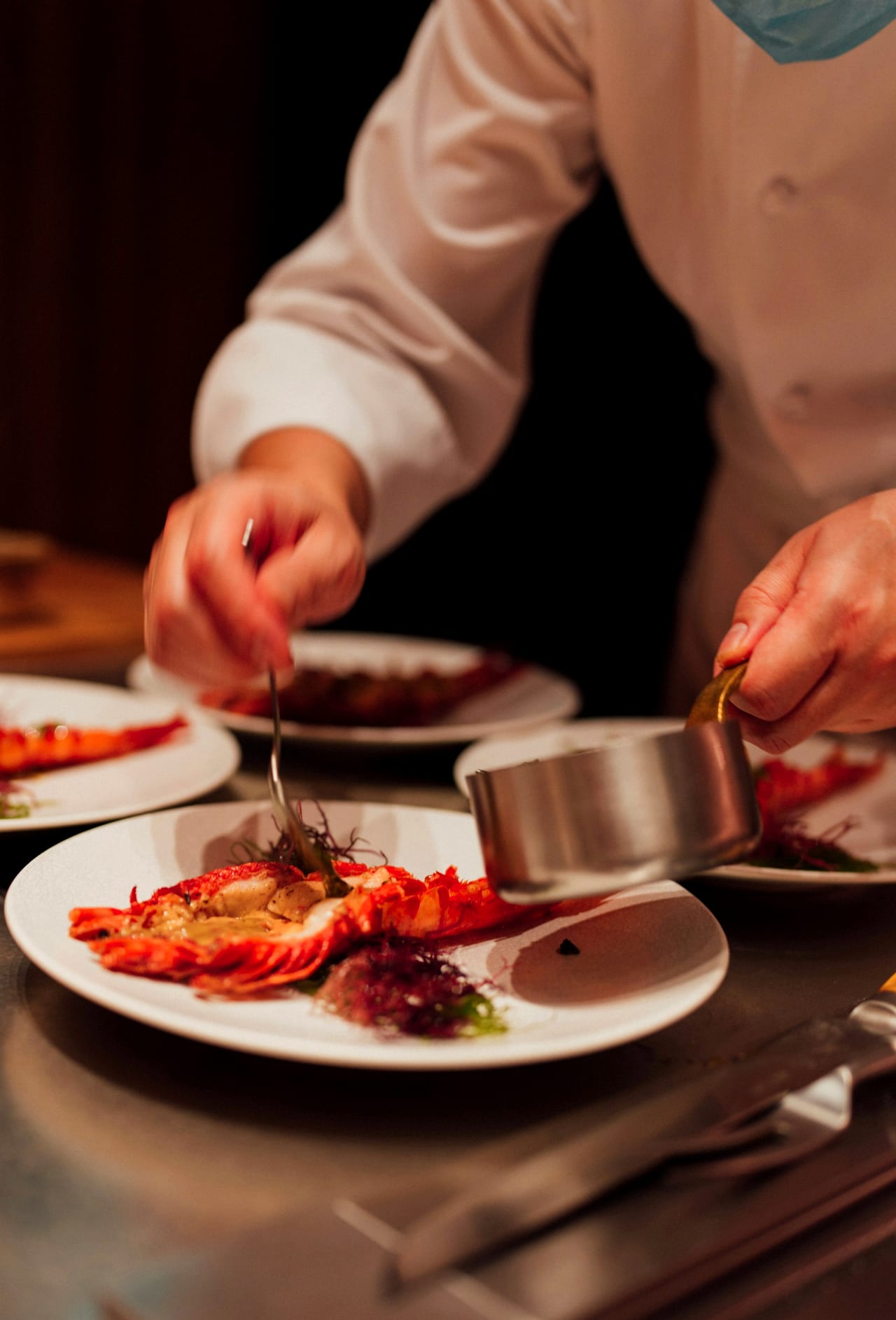 Hands finishing a dish at the pass during service