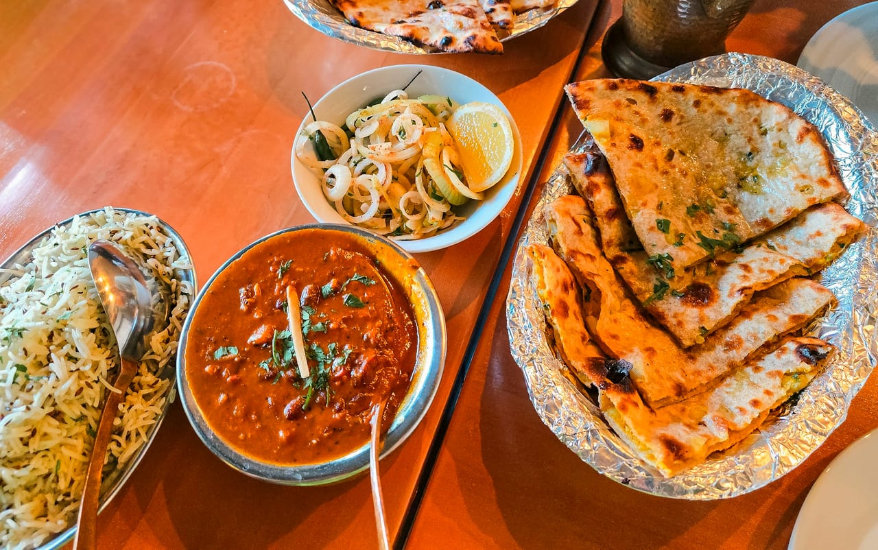 A curry-house spread of dal, rice, salad and flatbreads on a table