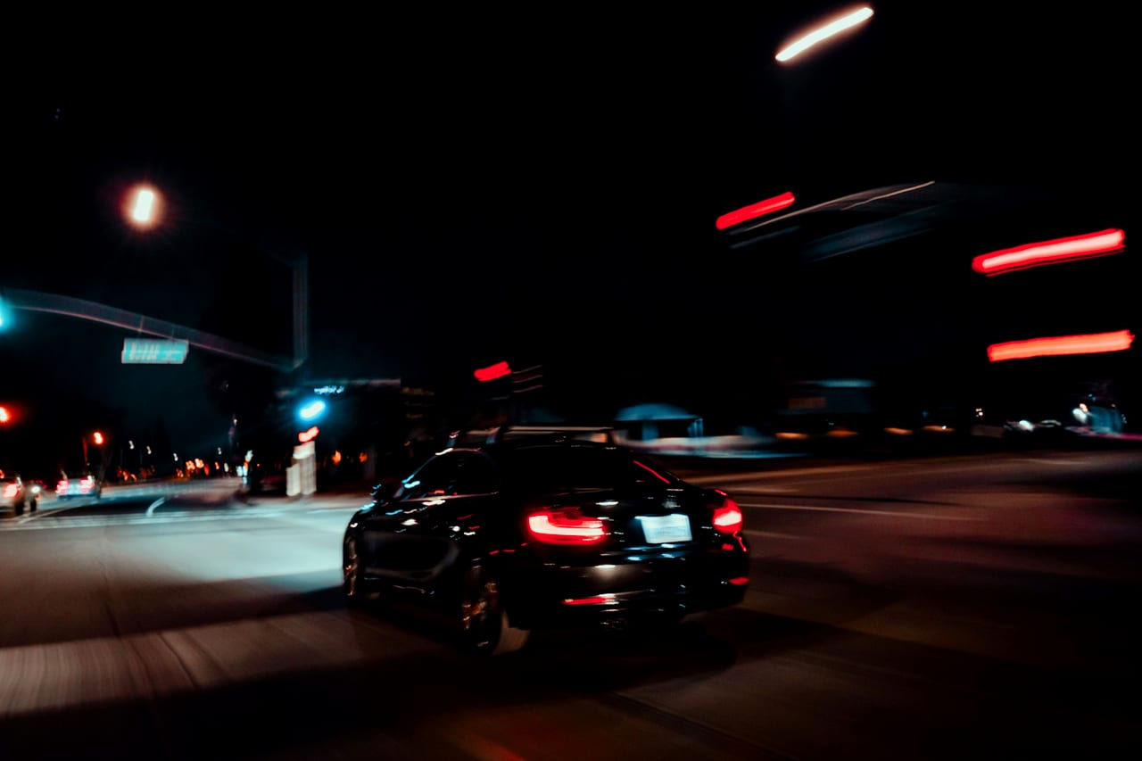 A car on a lit street at night