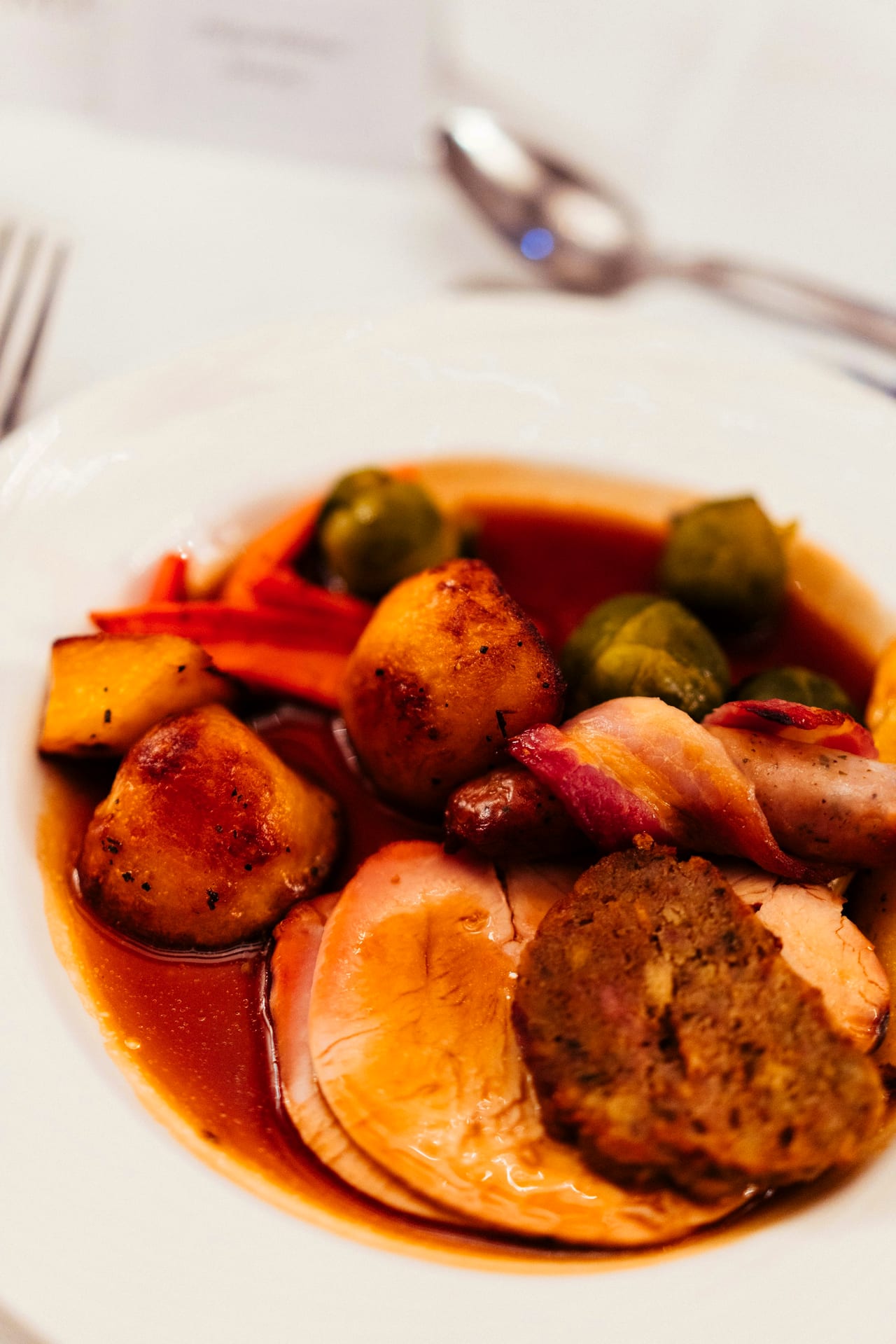 A Sunday roast plated with roast potatoes, sprouts, pigs-in-blankets and gravy